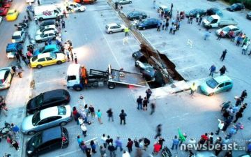 Γερανός απομακρύνει τα αυτοκίνητα που «ρούφηξε» το πάρκινγκ στην Καλλιθέα  